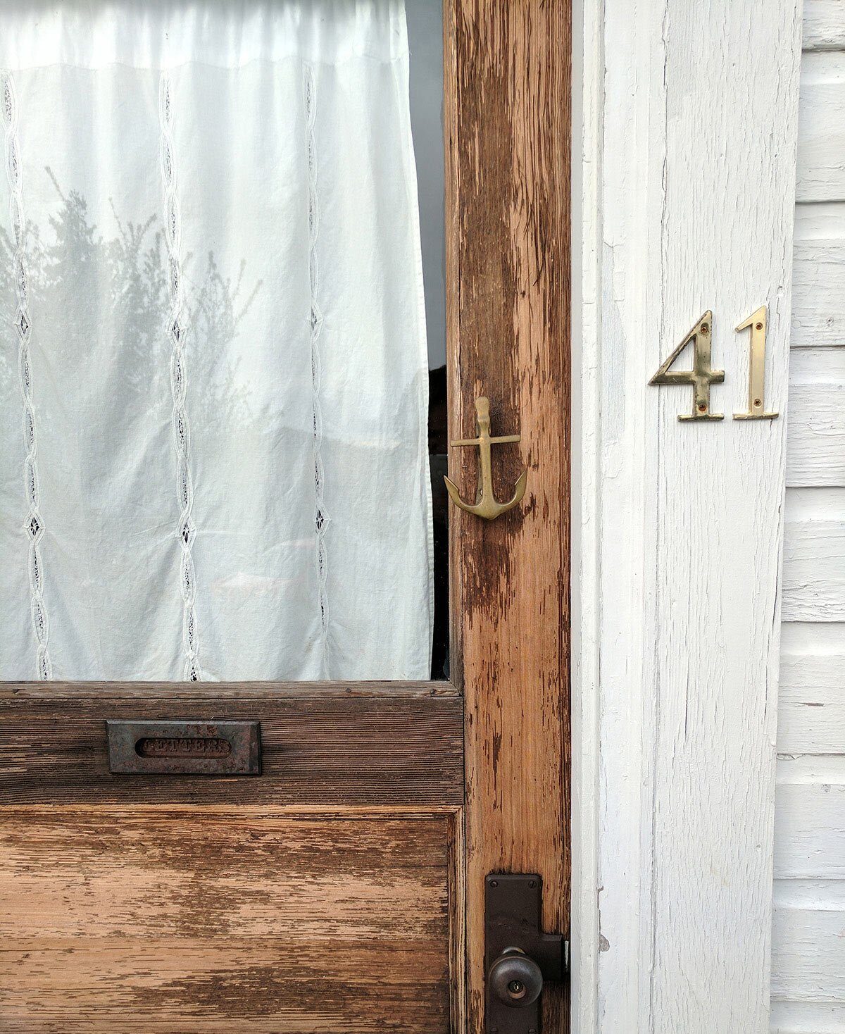 A wood door with brass numbers.