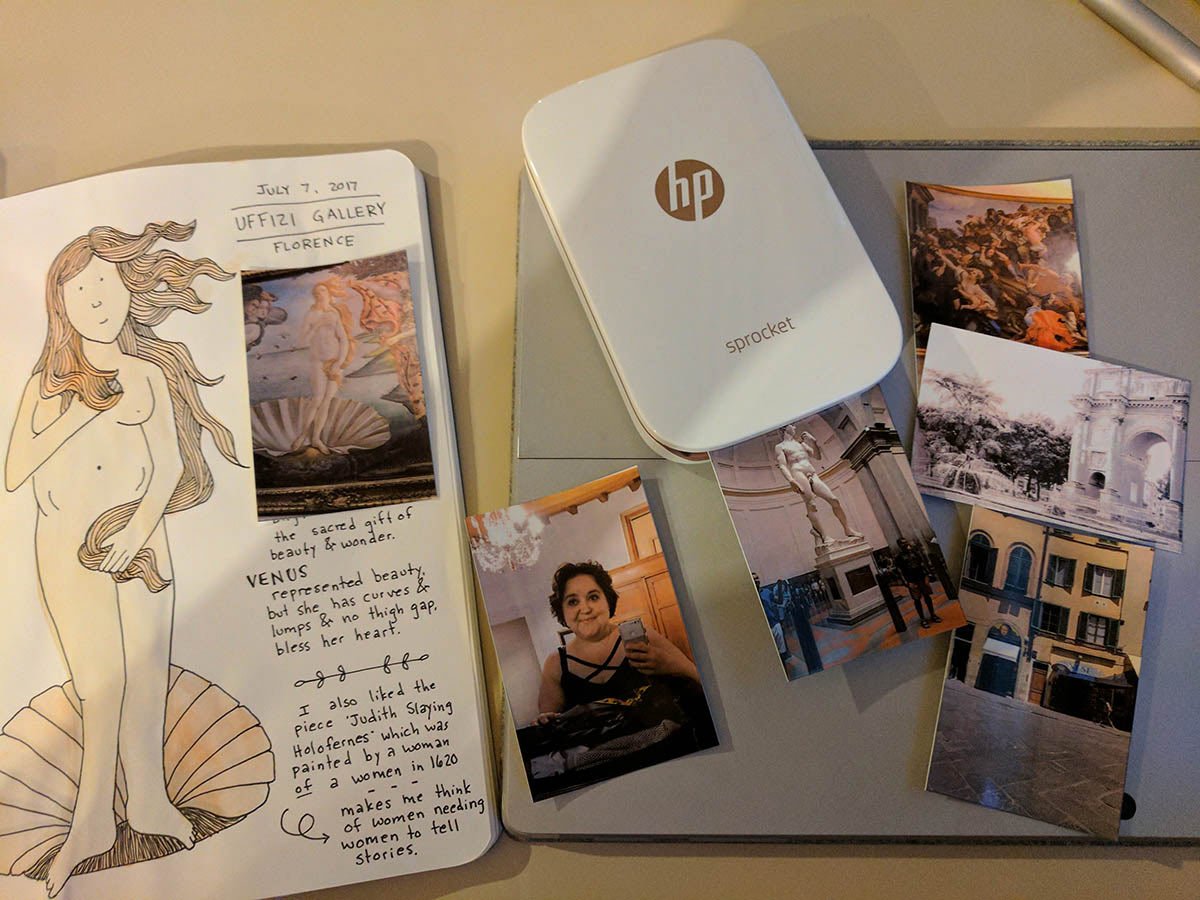 A travel printer shown next to a travel journal.