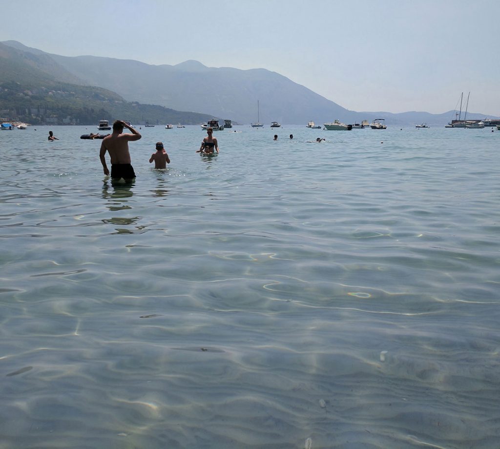 Swimmers wading in the turquoise waters of the adriatic sea in croatia.