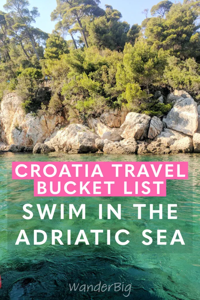 Turquoise green waters of the adriatic sea with craggy rocks and trees.