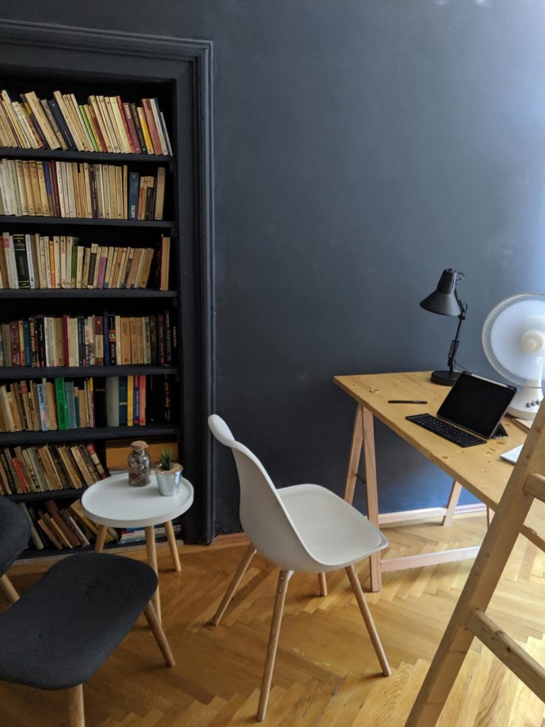 A workspace in a modern short term rental with a molded chair and unfinished table.