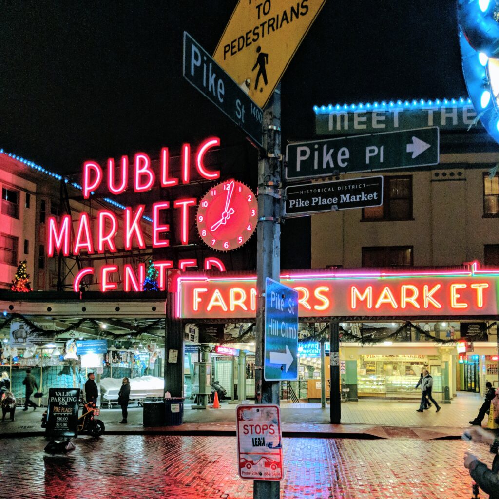 Neon signs illuminated at pike place market after dark.