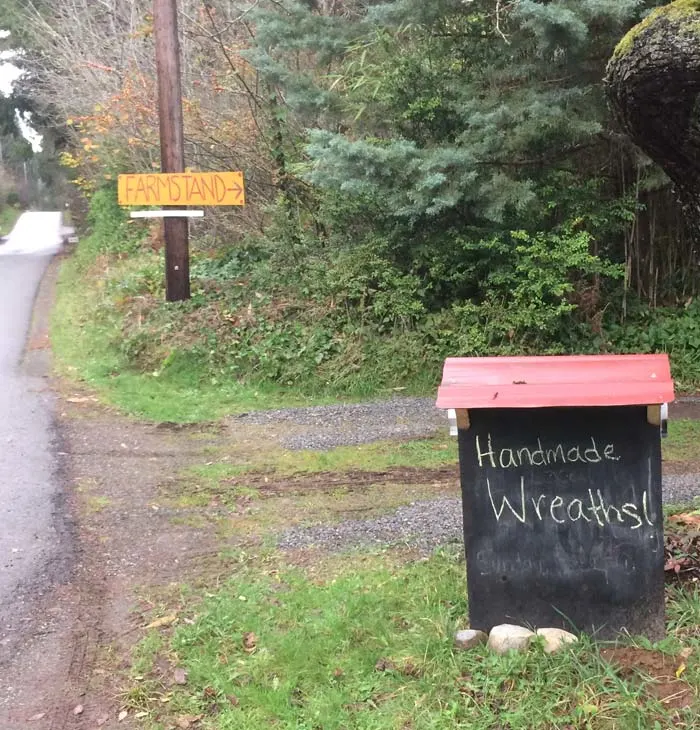 A rural farm stand on bainbridge island in western washington advertising handmade wreaths