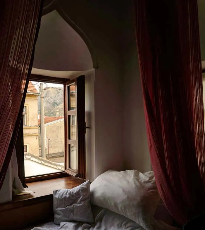 A hotel room in bosnia with turkish windows and drapes