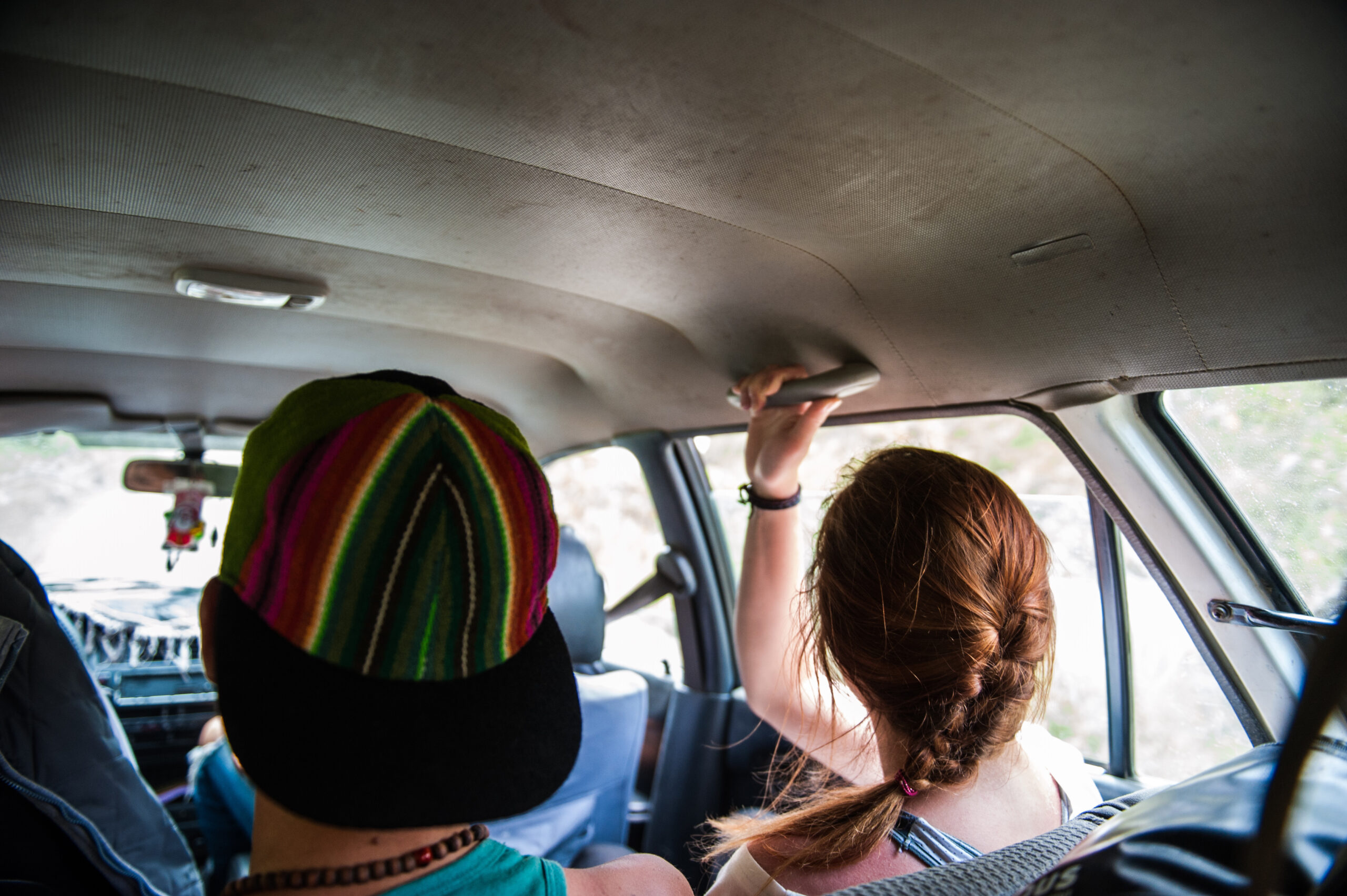 Two passengers in a shared taxi van in peru.