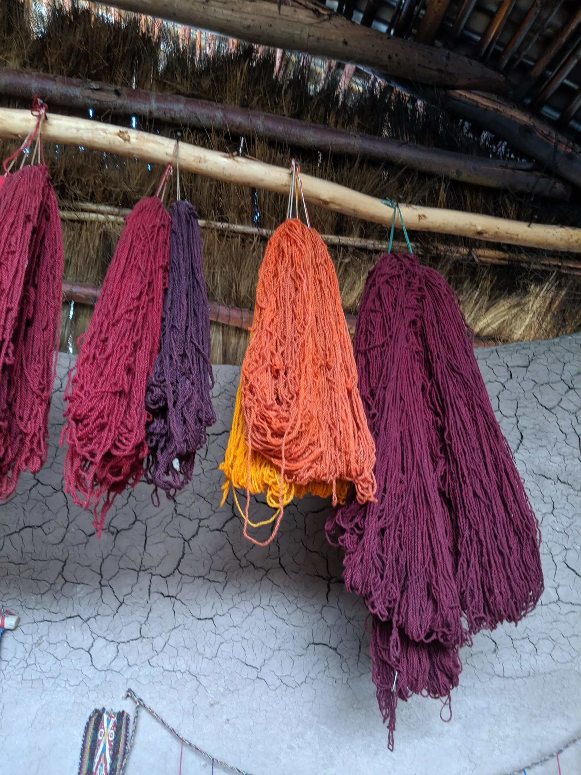 Bundles of freshly dyed yarn hanging to dry in a hut in peru.