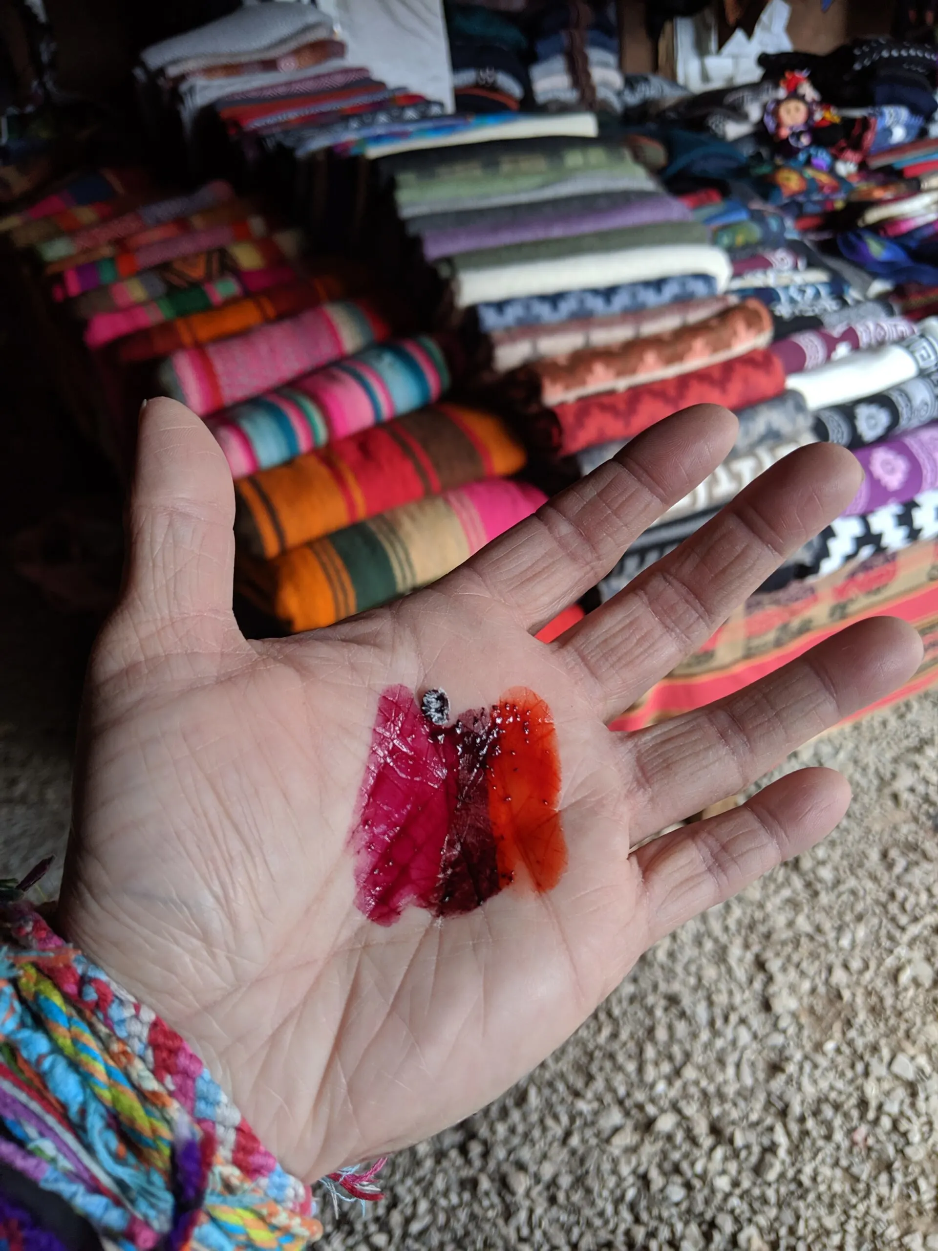 Close-up of a tourist hand showing different dyes used for dying textiles.