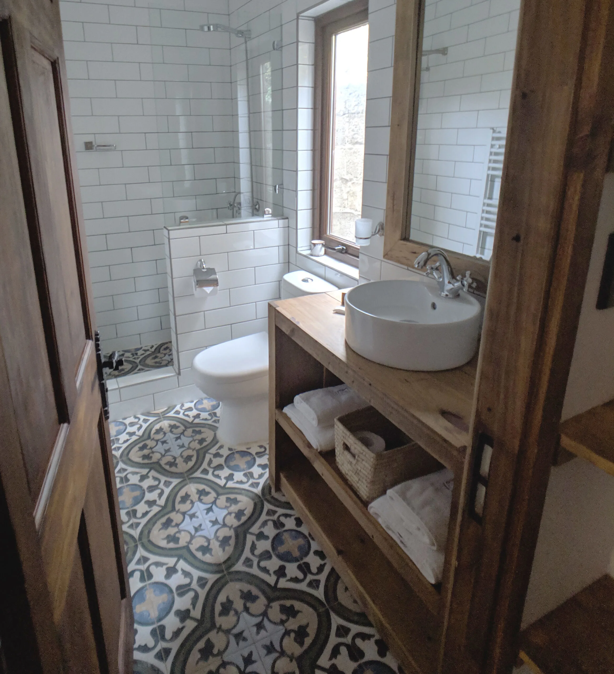 An airbnb bathroom with open shelving for guests personal care products.