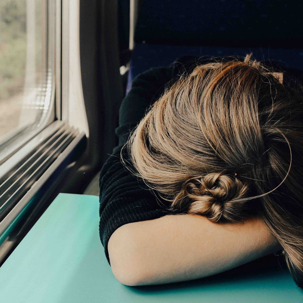A woman napping on a train.