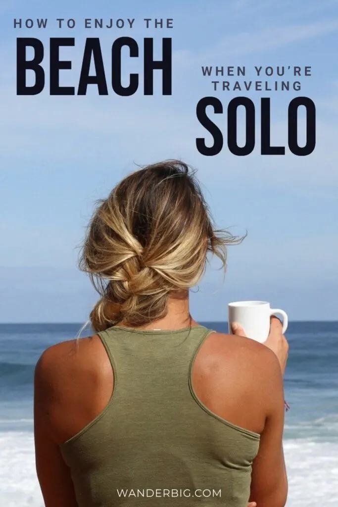A woman stands on the beach with a drink