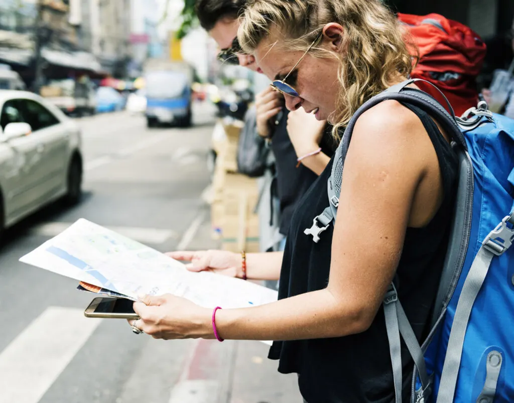 Two travelers navigating a city look at a map.