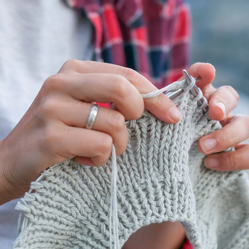 A woman's hands shown knitting.