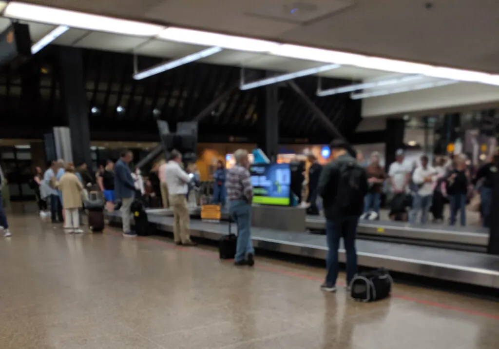 Seatac airport's baggage claim area includes signs directing travelers to the light rail station, which is the first step to get to bainbridge island.