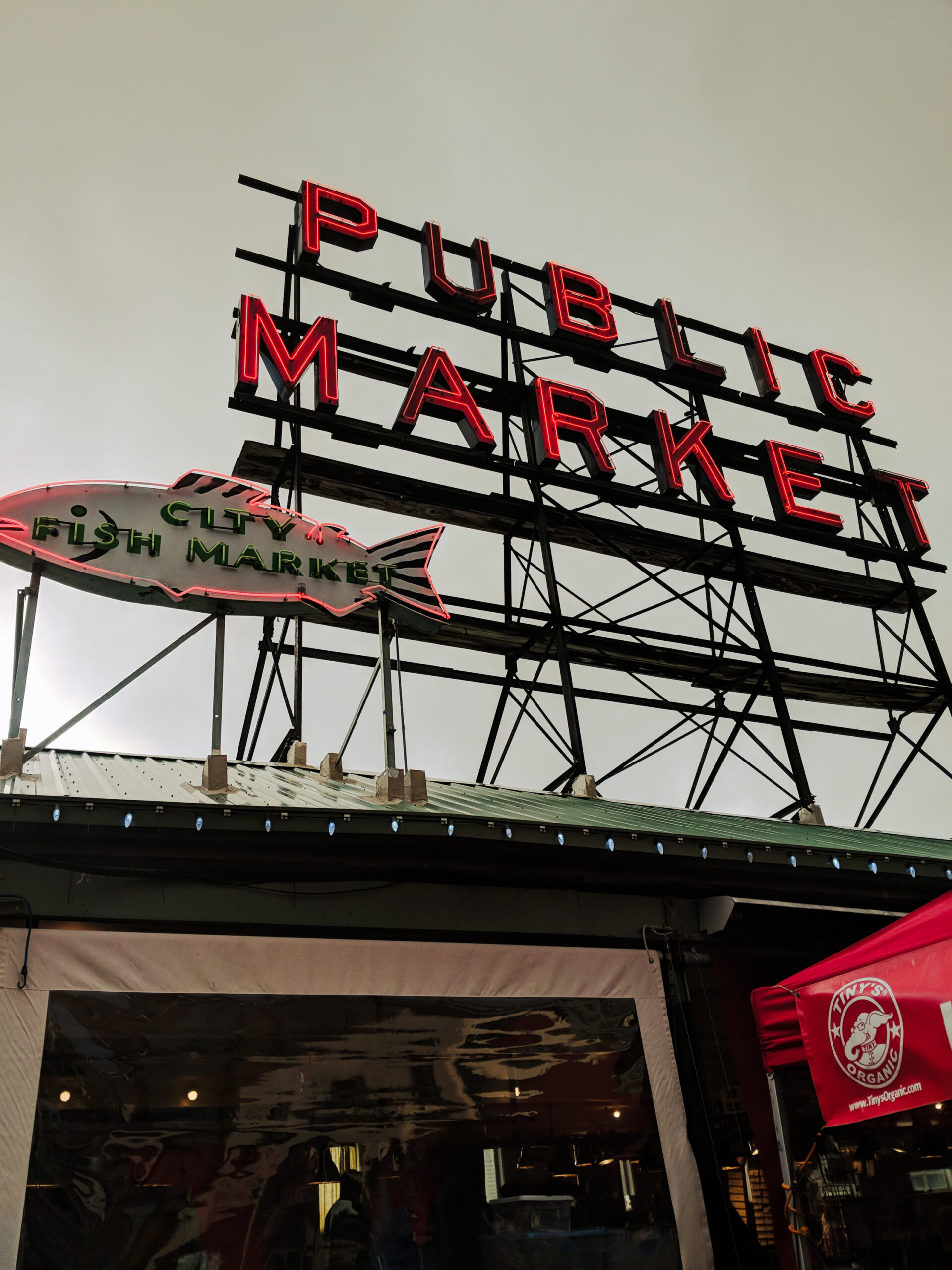 A neon sign at pike place market on an overcast winter day.