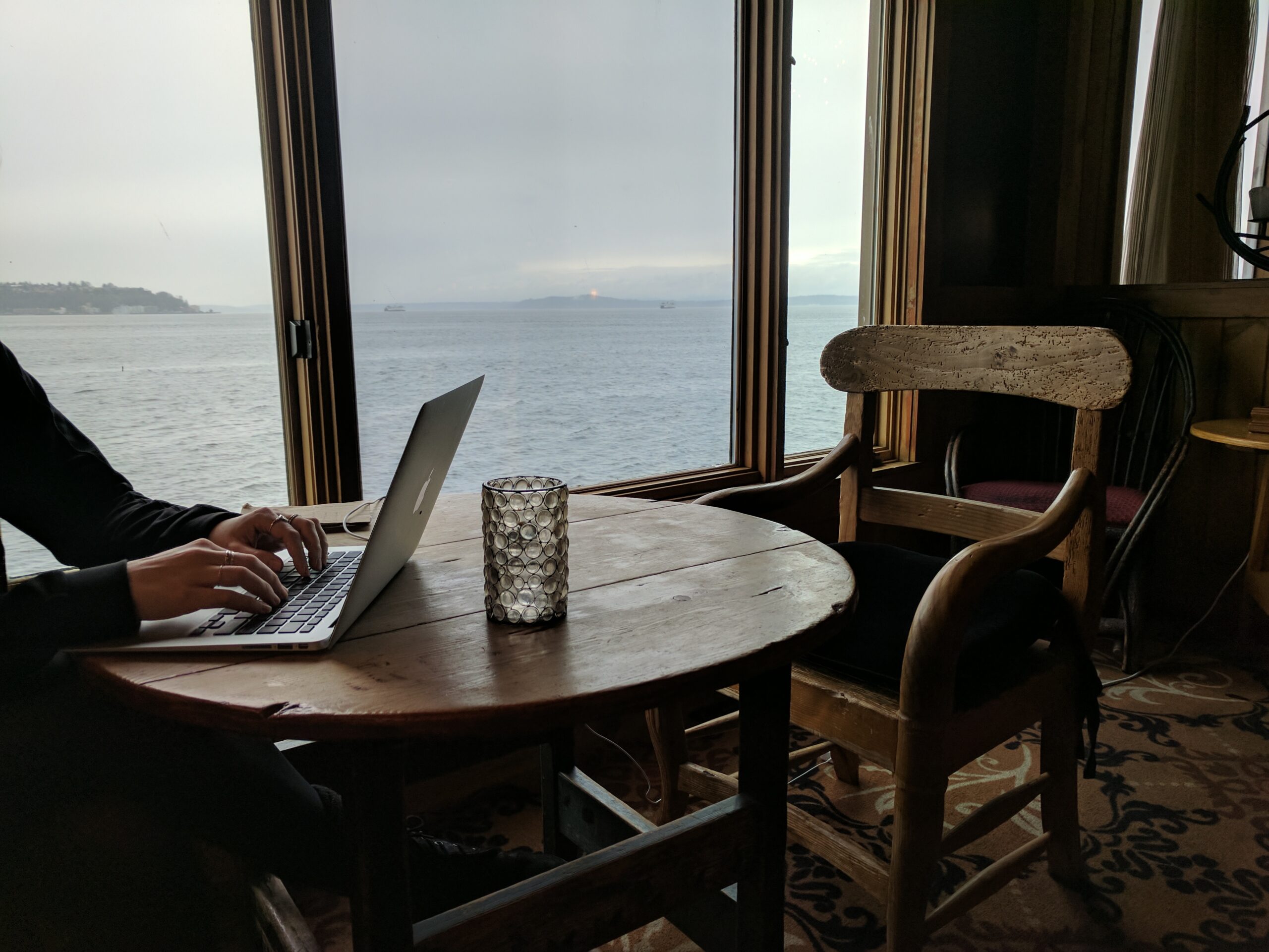 A table at the edgewater hotel, in front of a window with a elliott bay view.