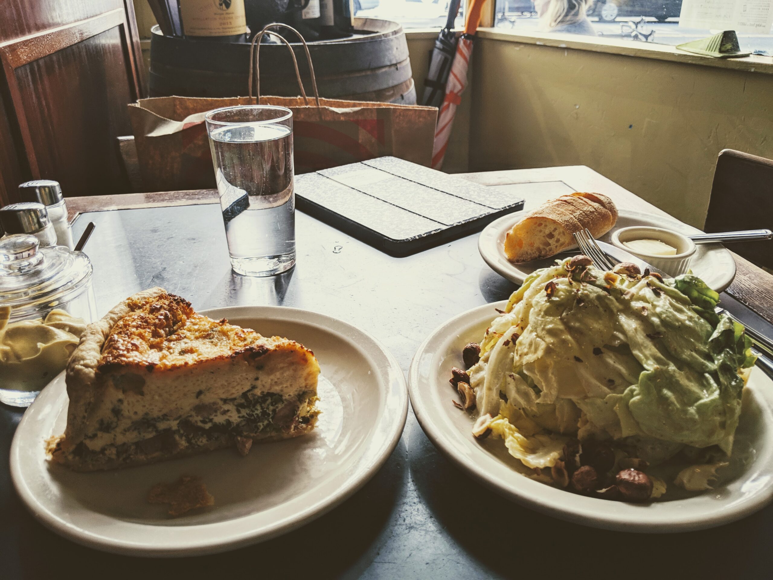 Quiche and a salad pictured on a table at le panier restaraunt.