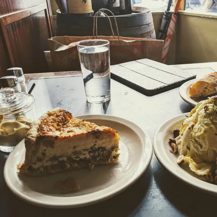 quiche and a salad pictured on a table at le panier restaurant.