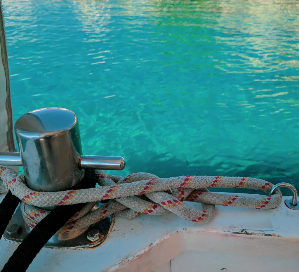 Turquoise blue waters shown behind nautical ropes.