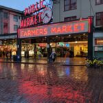 Neon signs illuminated in the rain at pike place market.