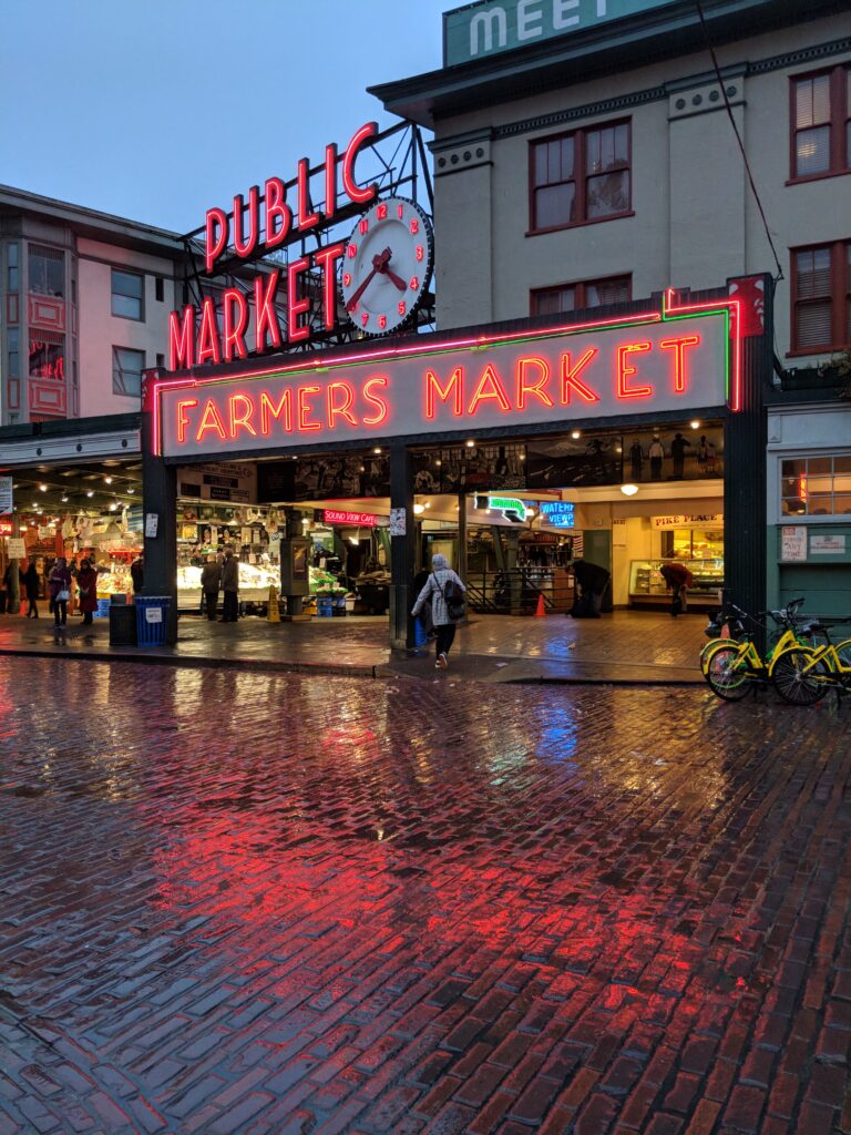 Neon signs illuminated in the rain at pike place market.