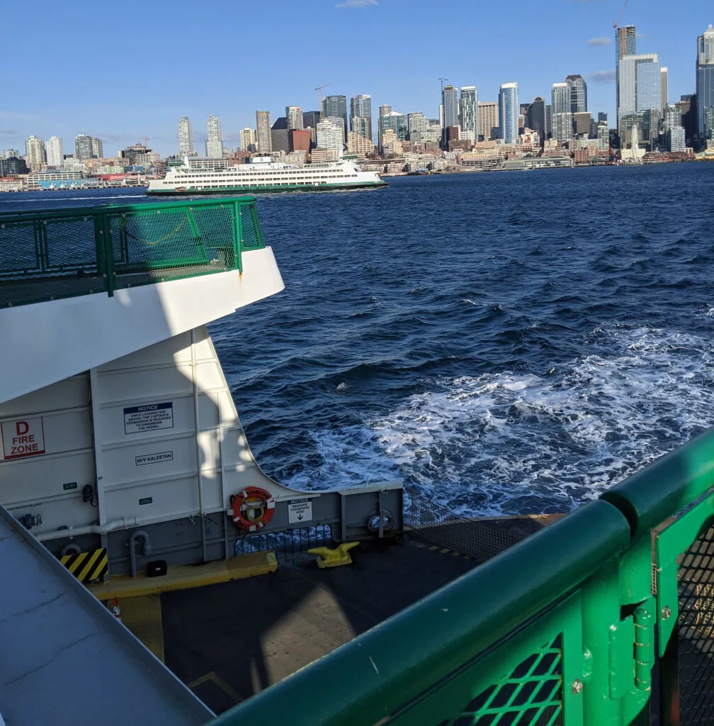 Washington state ferry leaving seattle bound for bainbridge island, with the seattle skyline in the background.