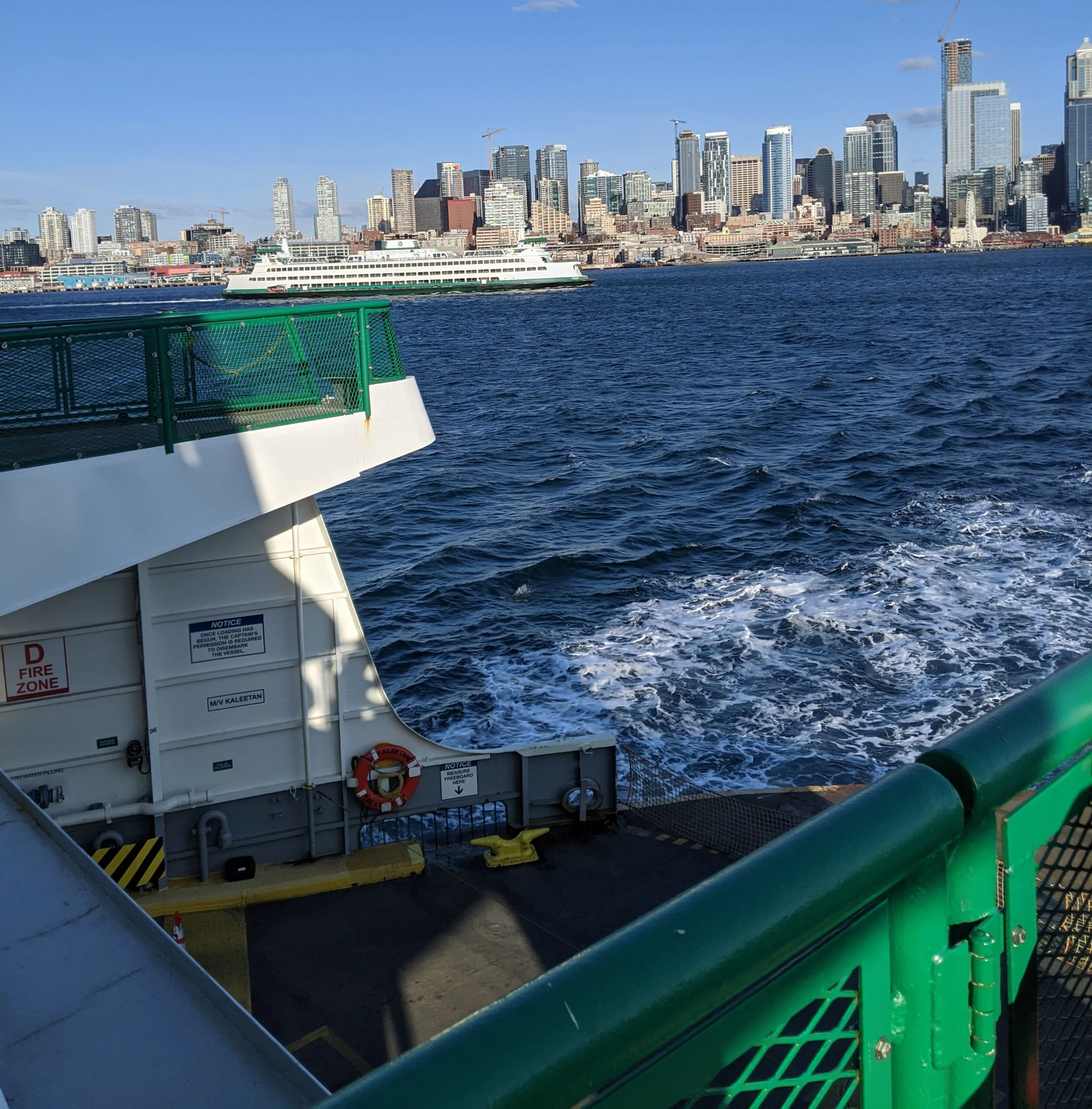 Washington state ferry leaving seattle bound for bainbridge island, with the seattle skyline in the background.
