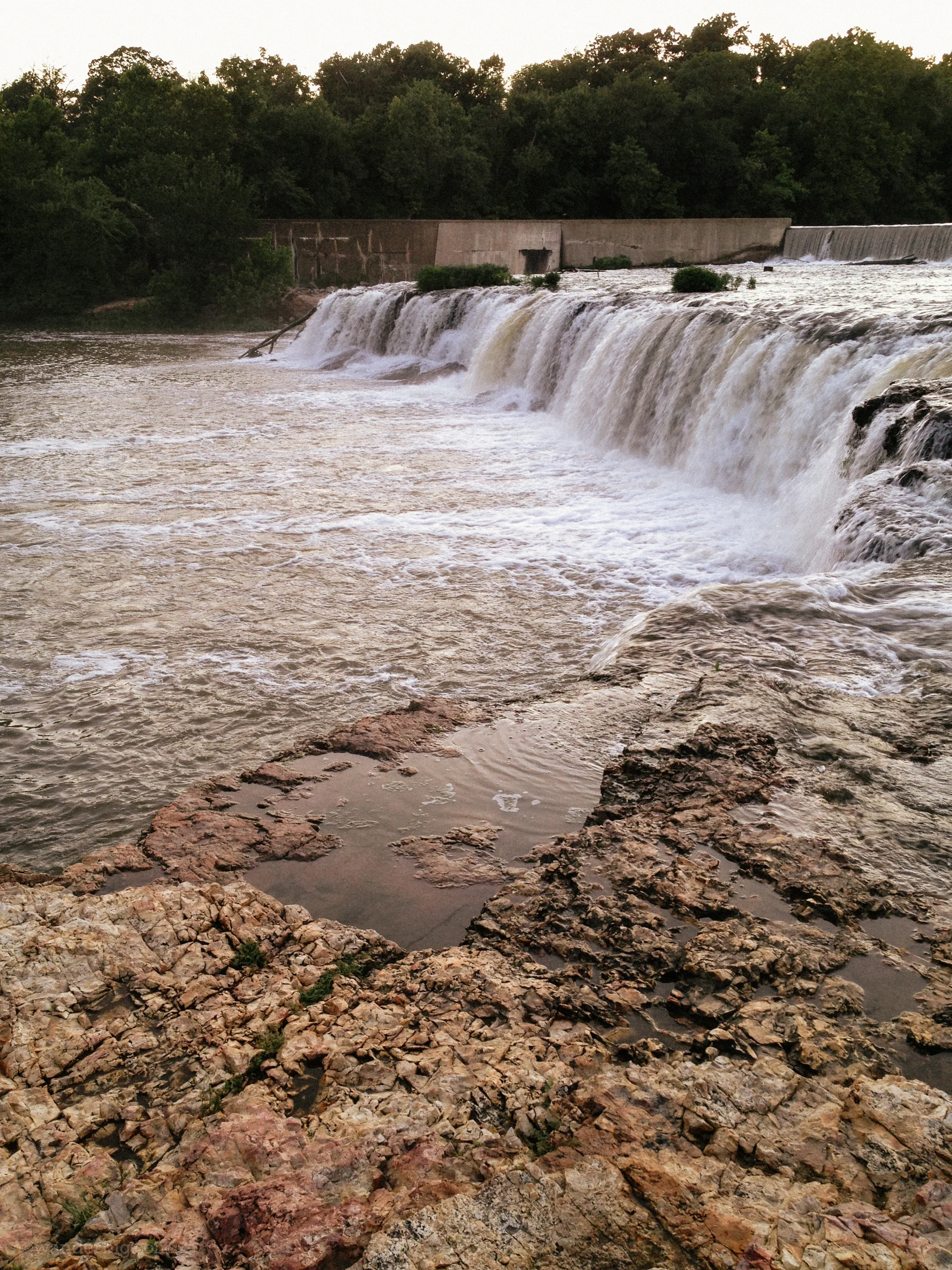 Spring fed waters from shoal creek flow over the chert rock formation making up grand falls waterfall, near joplin, mo.