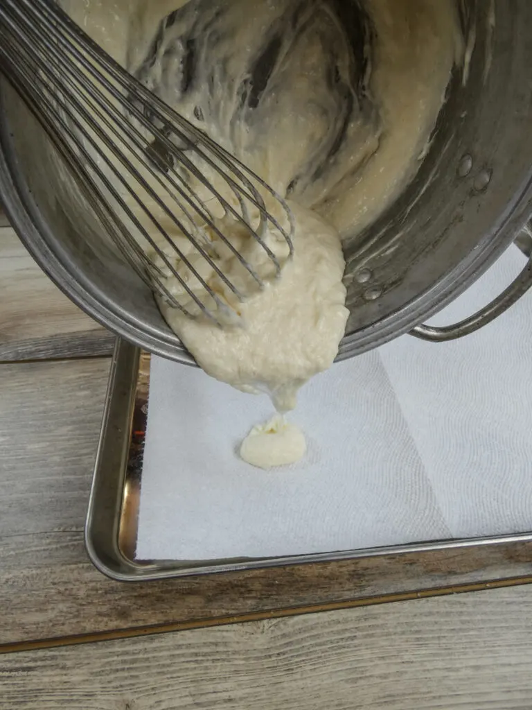 Pouring melted laundry detergent onto a detergent sheet.