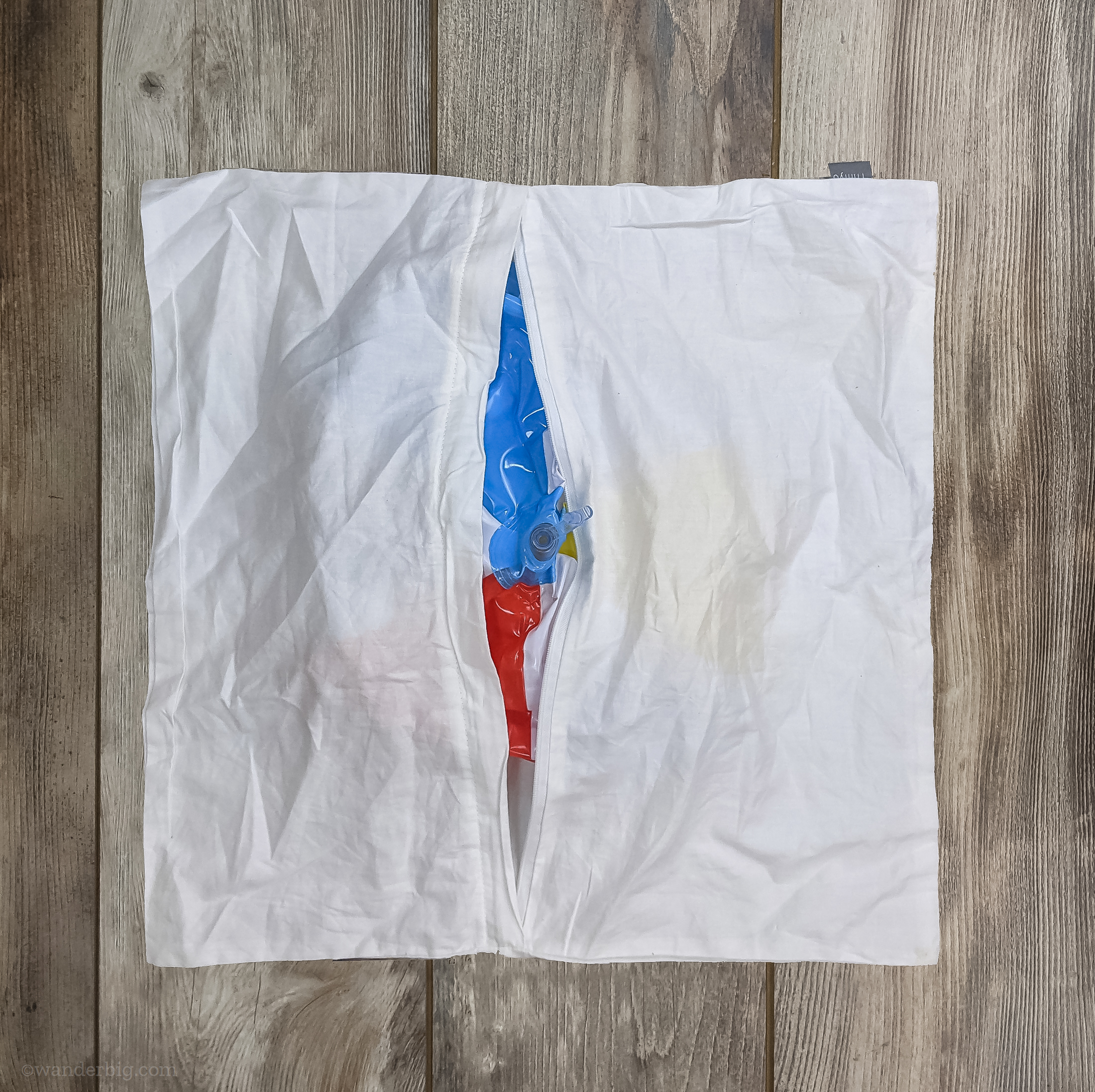 An uninflated beach ball inserted into a zippered pillowcase.