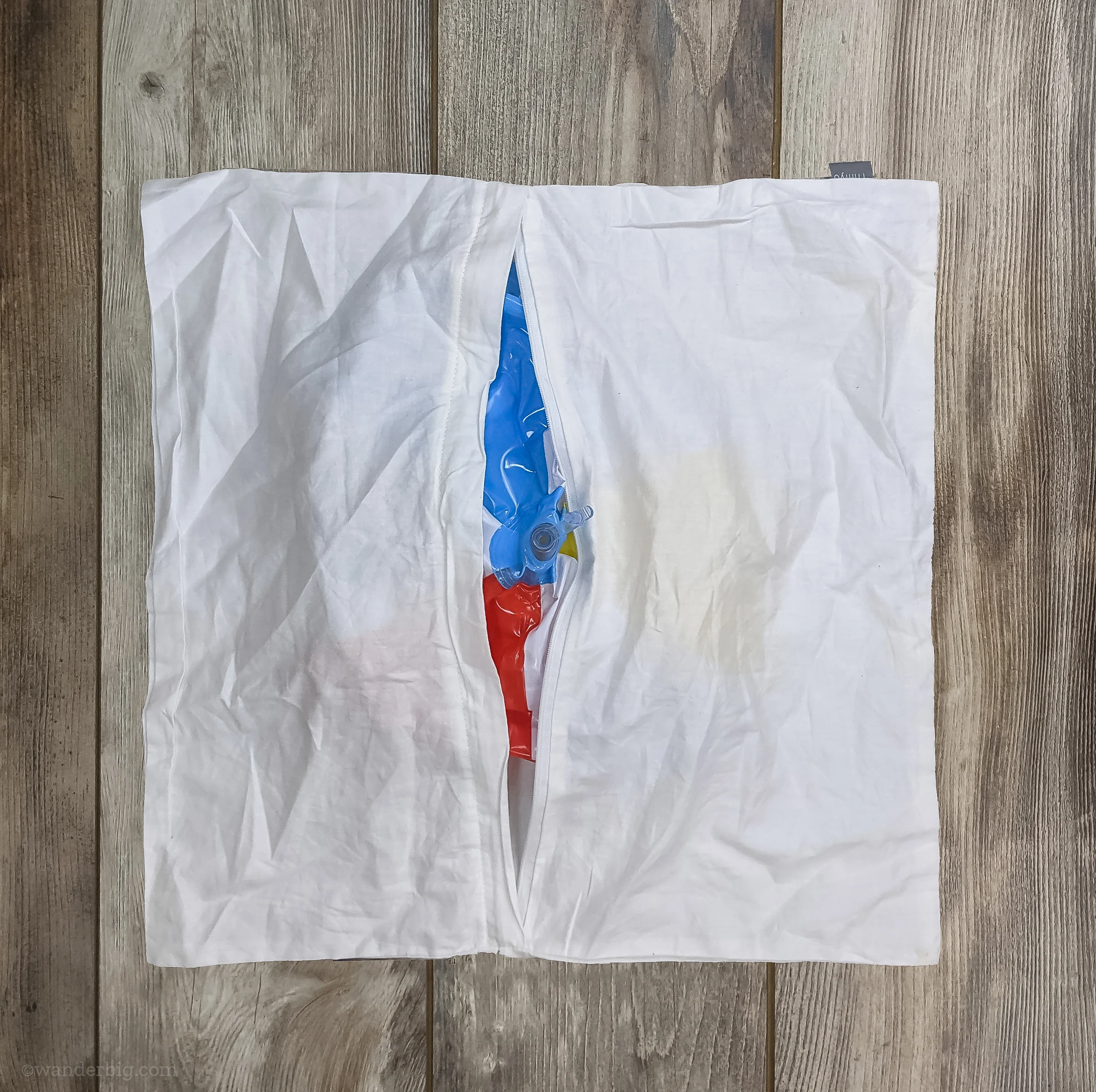 An uninflated beach ball inserted into a zippered pillowcase.
