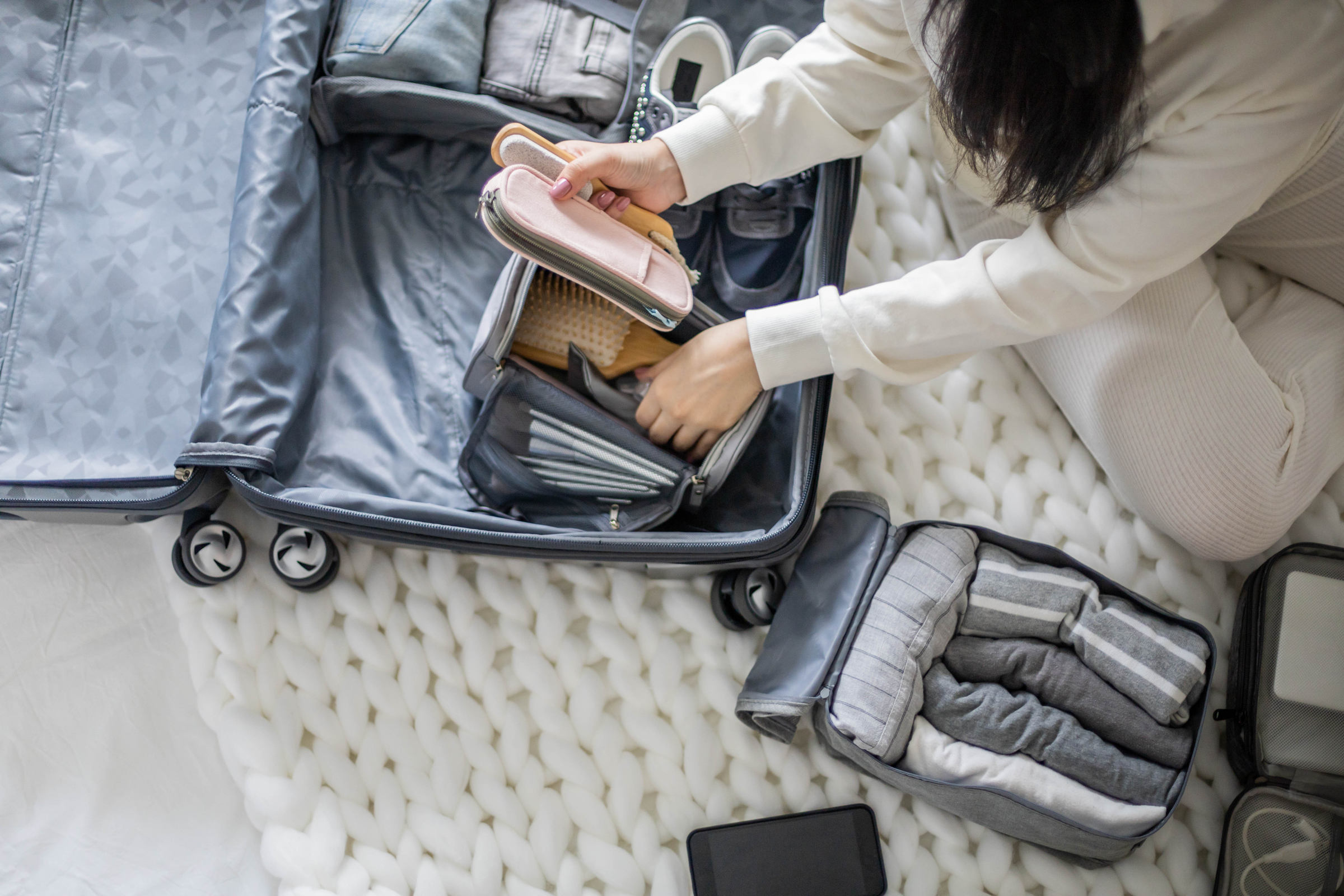 A woman packs a suitcase.