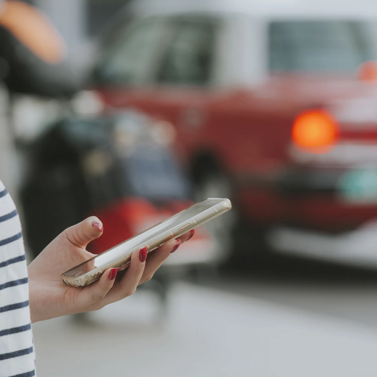 Woman with a smartphone ordering taxi cab or alternative modes of transport.