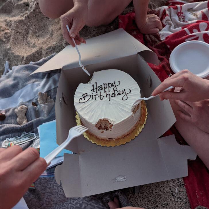 A 40th birthday cake being eaten on a beach in Hawaii