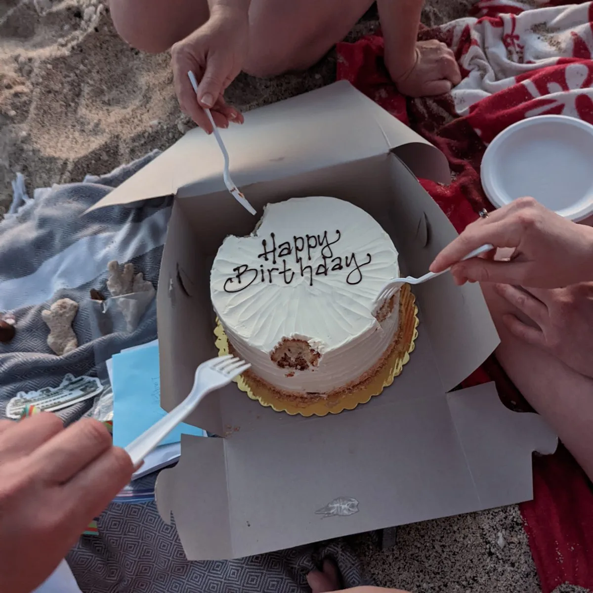 A 40th birthday cake being eaten on a beach in hawaii