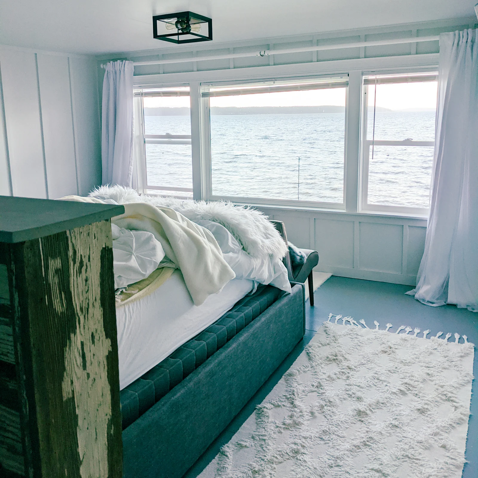 A bed overlooking the puget sound in a furnished finder apartment.