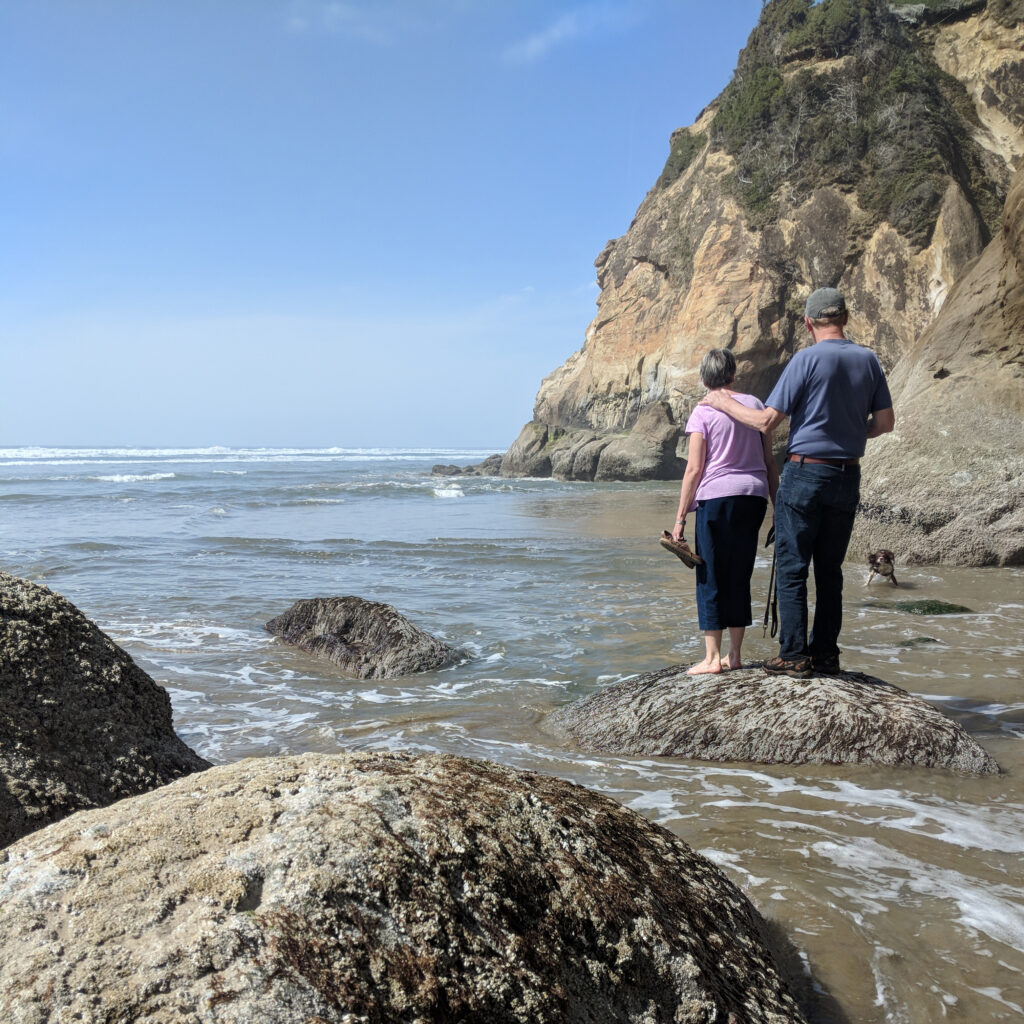 People walking on a beach in oregon on a sunny day.