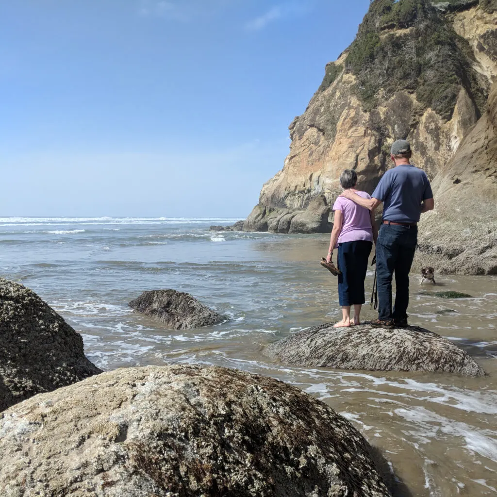 People walking on a beach in oregon on a sunny day.