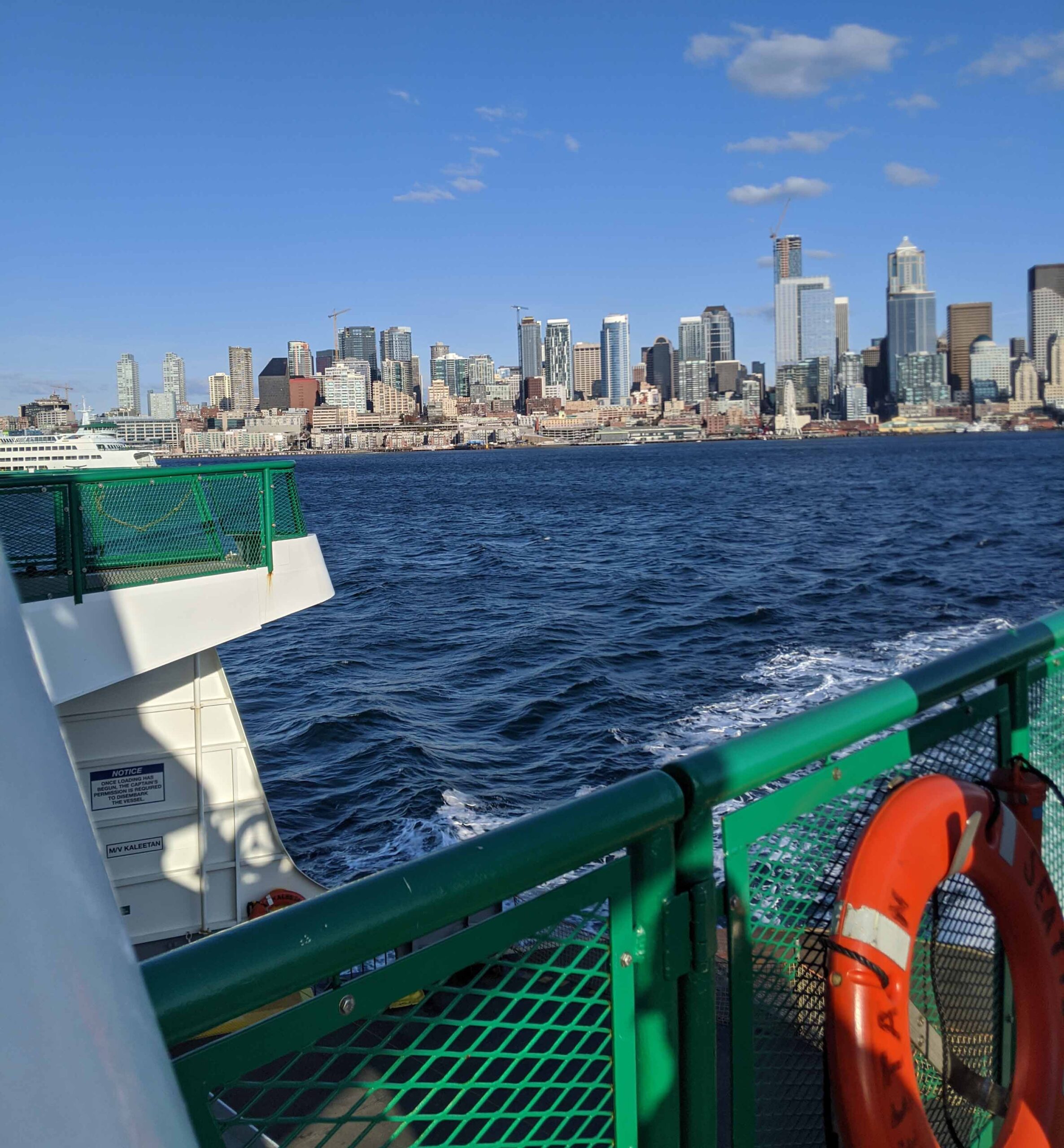 The view of seattle from the deck of a ferry headed to bremerton.