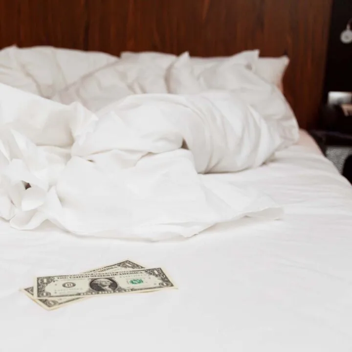 A two dollar tip on an unmade bed.