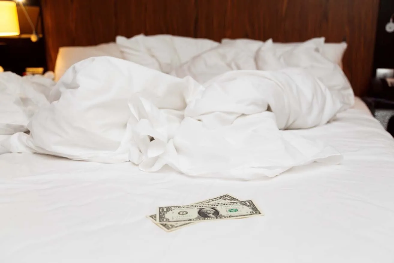 A two dollar tip on an unmade bed.