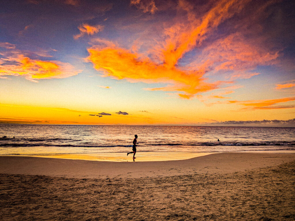 A jogger on a hawaiian beach on christmas day celebrating a tropical christmas.