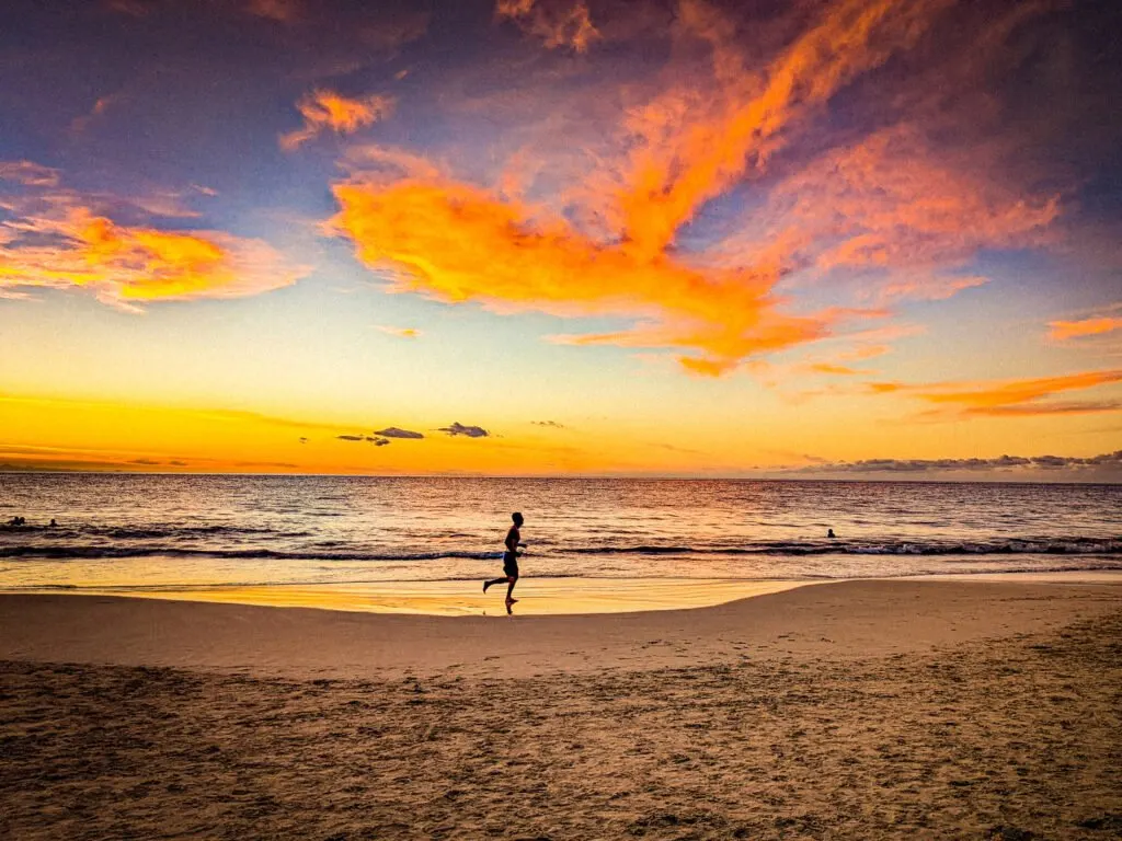 A jogger on a hawaiian beach on christmas day celebrating a tropical christmas.