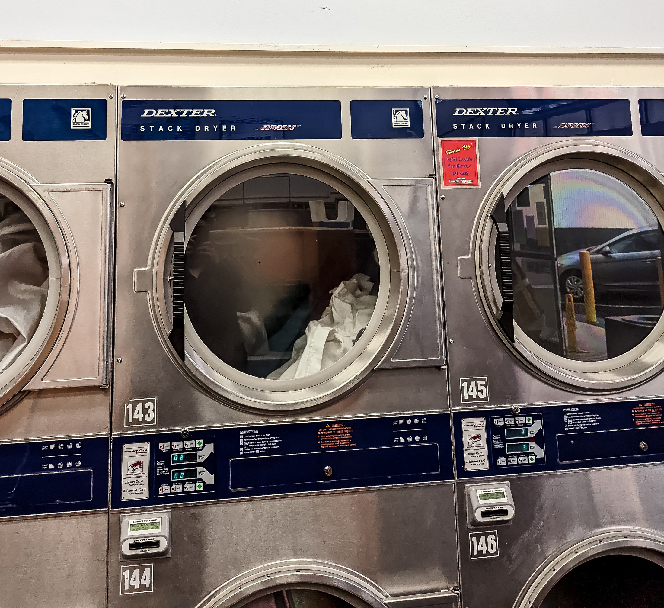 A wall of clothes dryers in a laundromat.