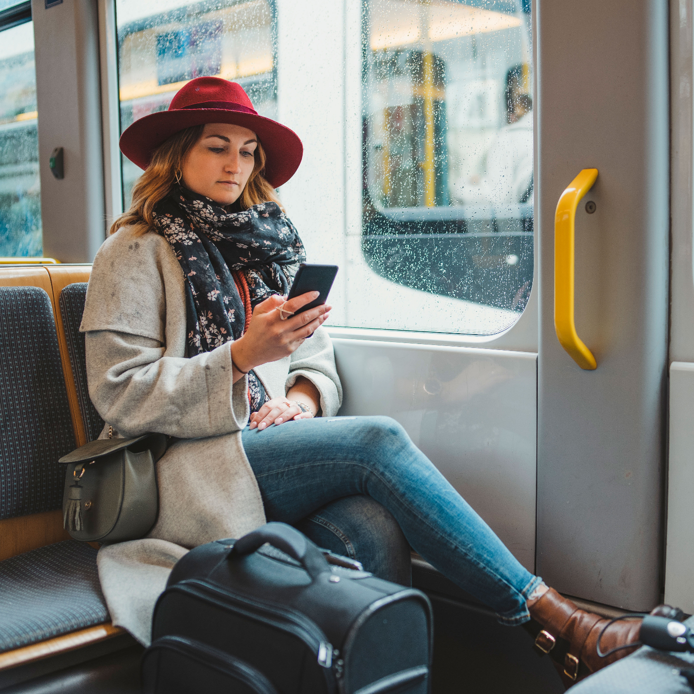 Woman on a train using public transportation to travel with a smaller carbon footprint.