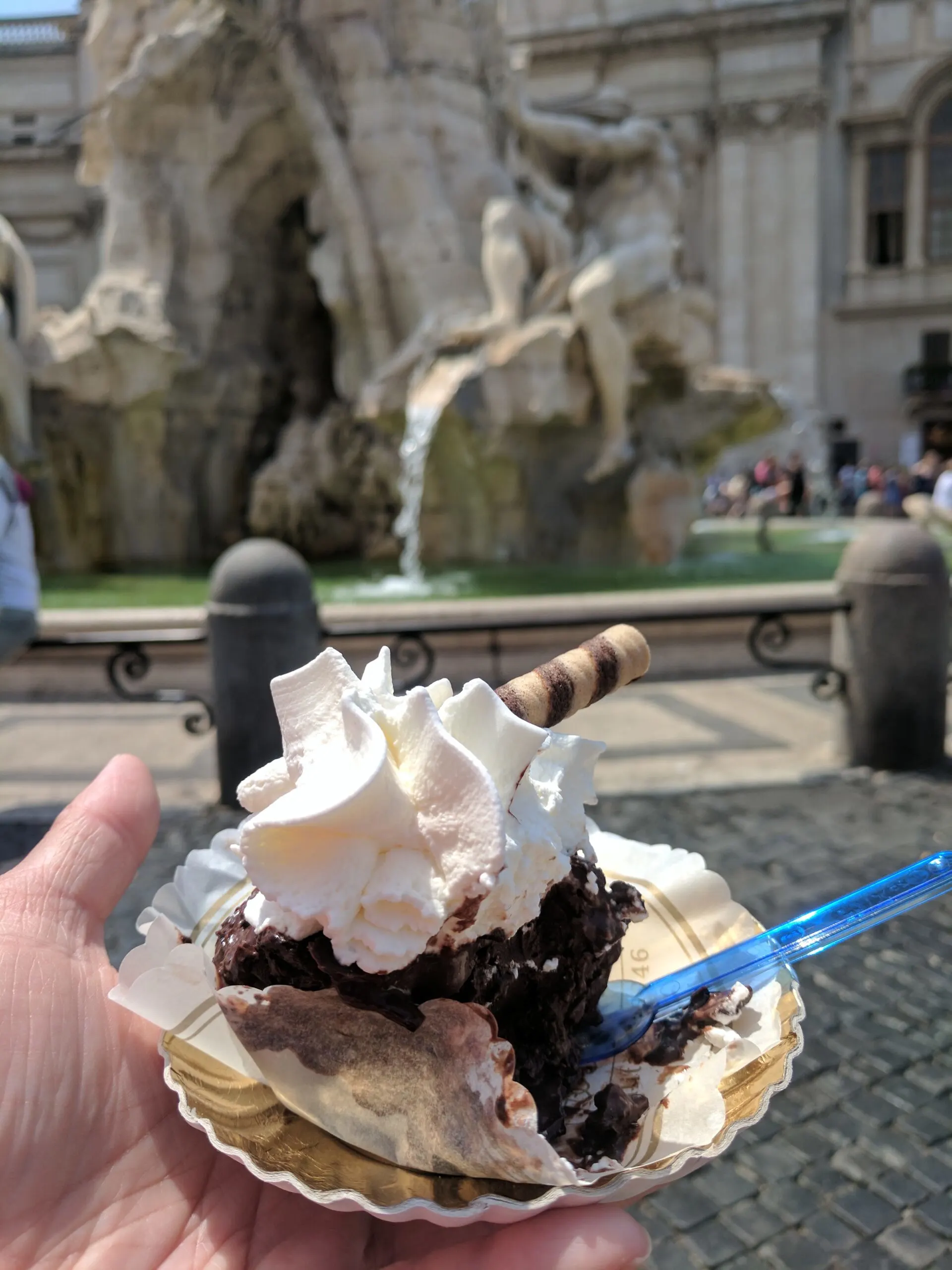 A cupcake with a fountain and plaza in the background