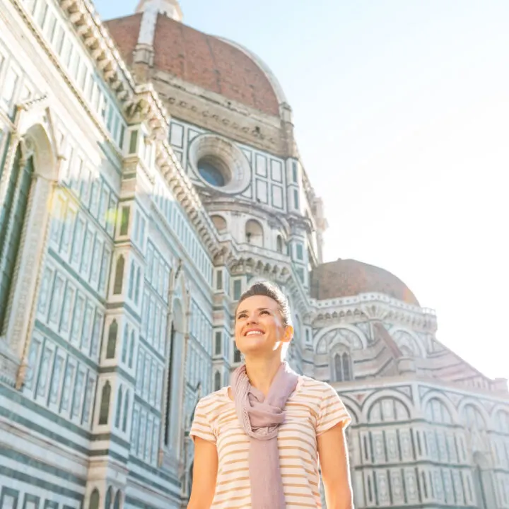 Young artist standing in front of Cattedrale di Santa Maria del fiore in Florence, Italy.