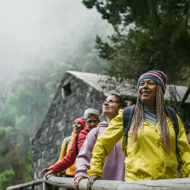 A group of women travelers walk along a foggy path.