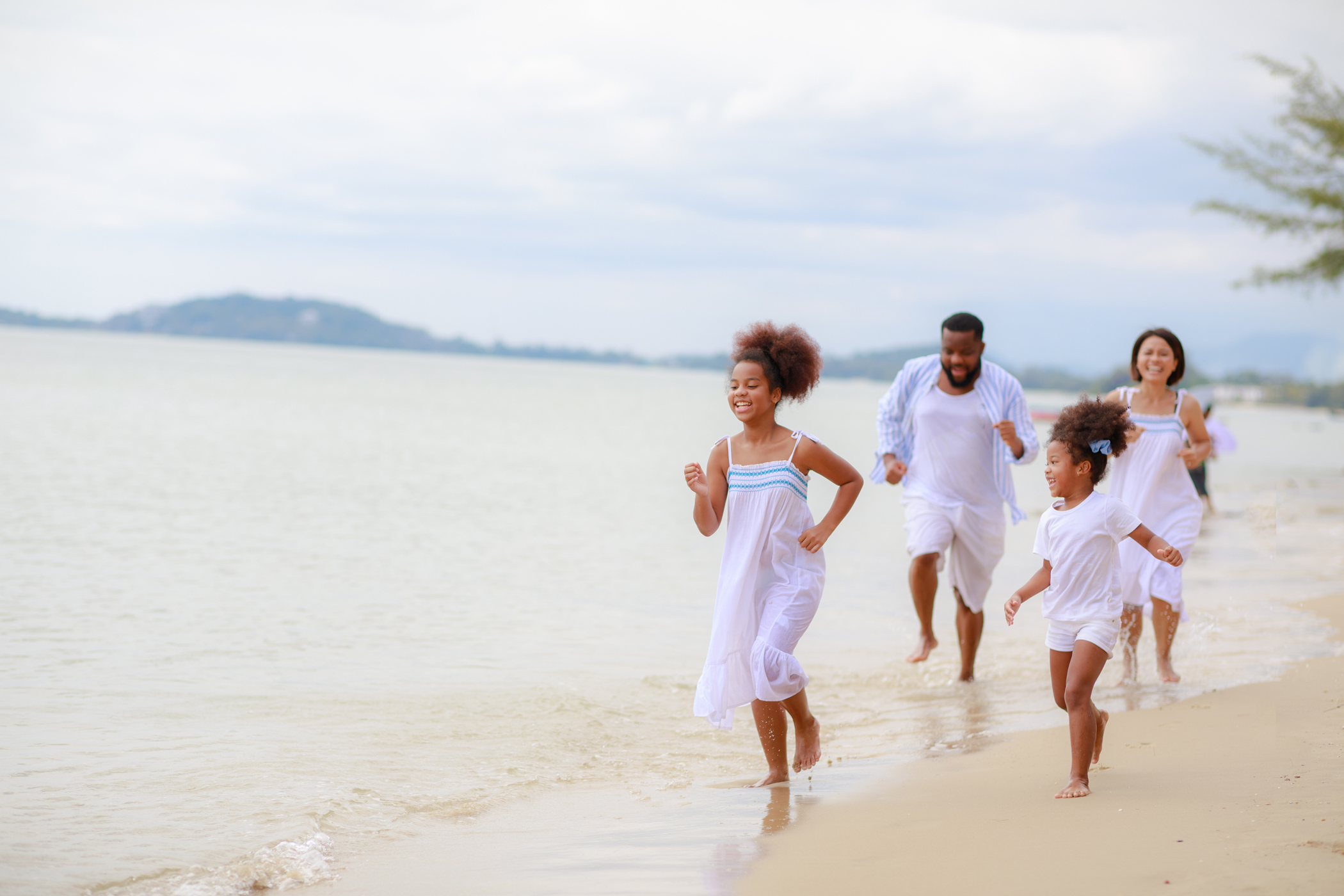 A family  running down the beach on vacation.