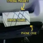 A cell phone mounted on the tray table on back of an airline seat for easy viewing.