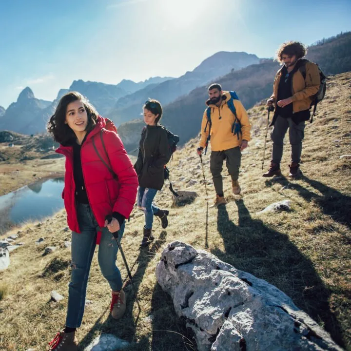 Group of hikers walking on a mountain at autumn day